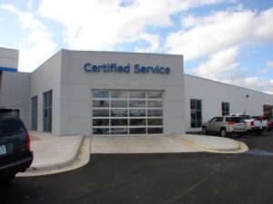A car dealership with a certified service sign on the front.