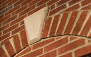 A brick wall with a corner of the building.