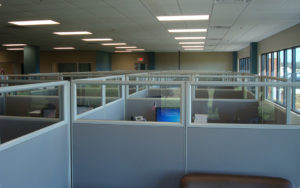 A room with many cubicles and windows