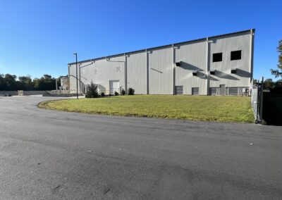 A large warehouse with a parking lot in the background.