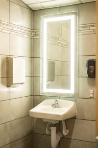 Bathroom with sink and illuminated mirror.