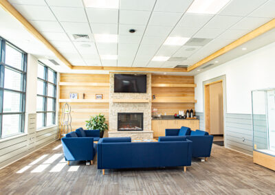 Modern waiting area with fireplace and blue couches.